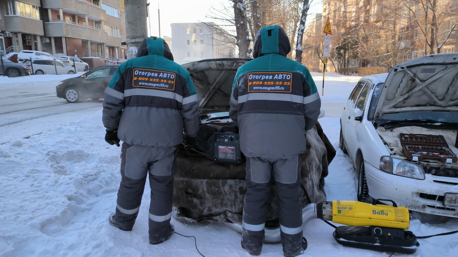 Экипаж «Отогрев 55» отогревает автомобиль тепловой пушкой на морозе в Омске